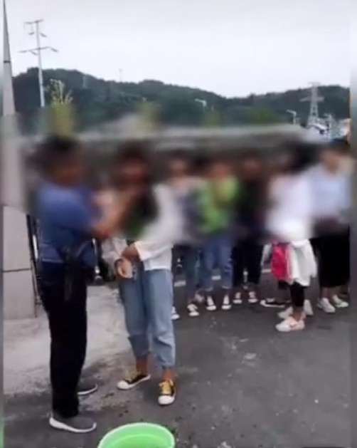 有男老師在校門以抹布為女學生「強制卸妝」。影片截圖