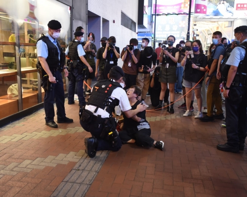 一名身穿黑衣的老婦被警員截查後情緒激動。