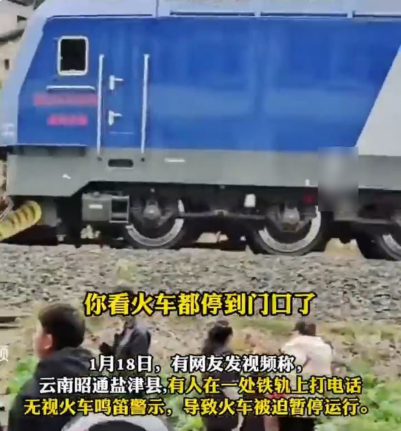 雲南有男子在鐵路軌上打電話，令火車急停6分鐘。影片截圖