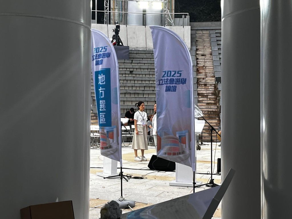 有工作人員在香港公園奧林匹克廣場佈置場地,當中有地區直選字眼的旗幟。李健威攝 有工作人員在香港公園奧林匹克廣場佈置場地,當中有地區直選字眼的旗幟。李健威攝