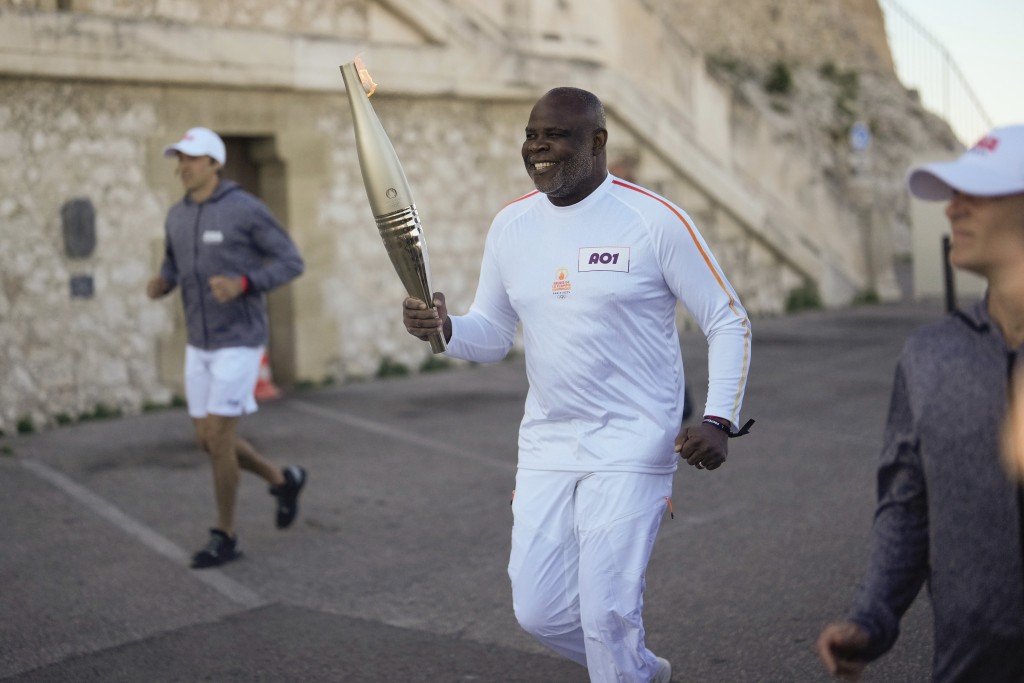 法国火炬手巴西尔·博利参加在法国南部马赛举行的奥运火炬传递第一阶段。 AP