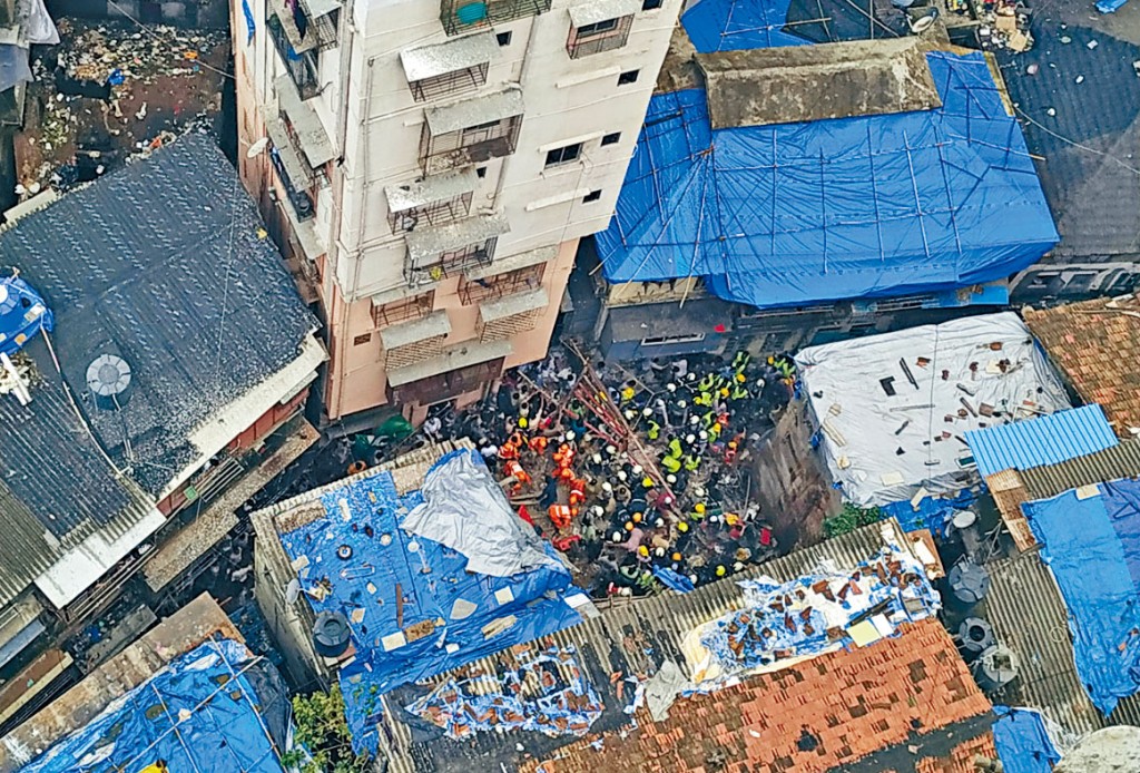 救援人員在塌樓現場搜尋生還者。