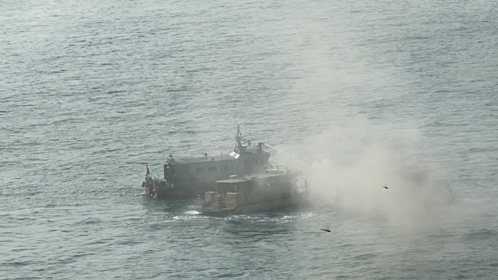 40尺长船只起火焚烧，冒出大量浓烟。刘汉权摄