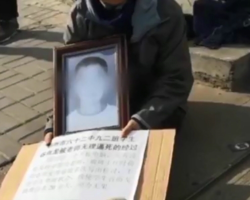 該學生家屬帶著孩子的遺照到學校大門前，要求校方給個交代。 網上圖片
