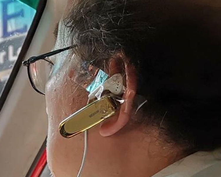 左耳戴著一個免提耳機,更用膠紙將一個連接電話的有線耳筒貼在左耳上。網民GeorGe Wong圖片