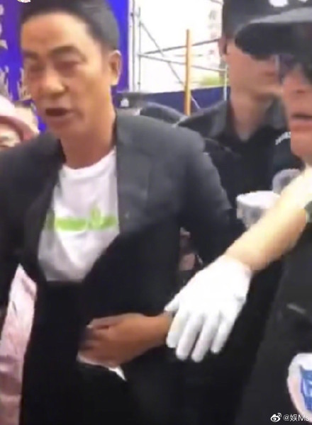 任達華自行步離現場時以手按著腹部。網圖