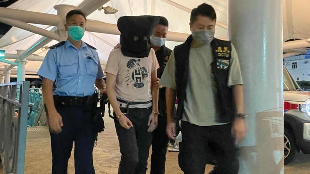 張敏懷(蒙頭者)在案件被揭發後遭警方拘捕。