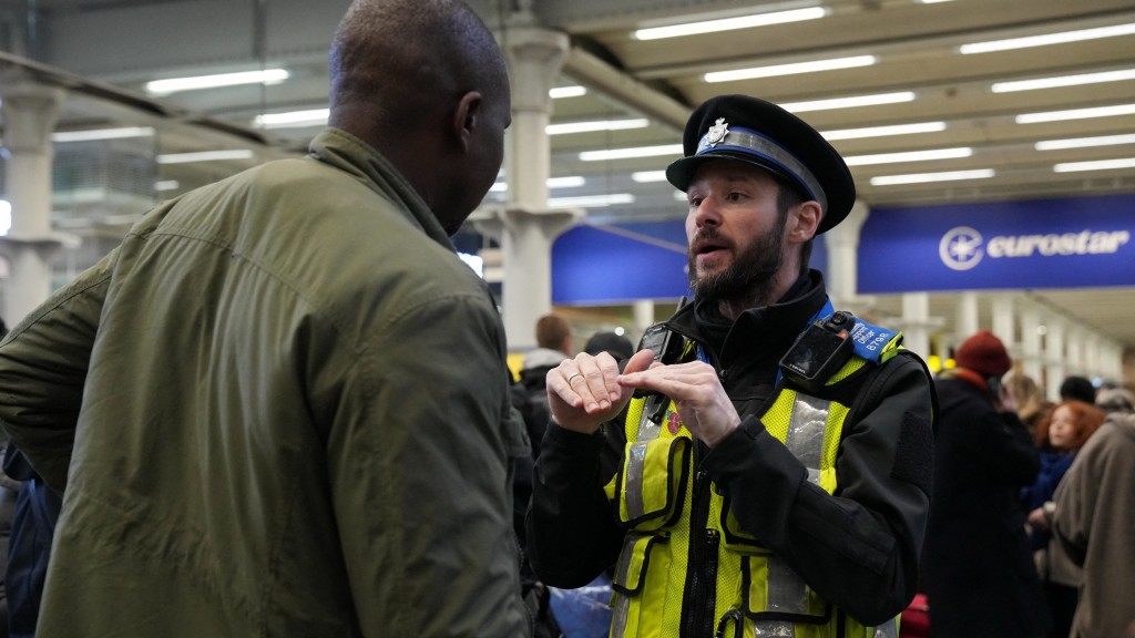 Eurostar因供電問題停駛，警員向乘客解釋。 路透社
