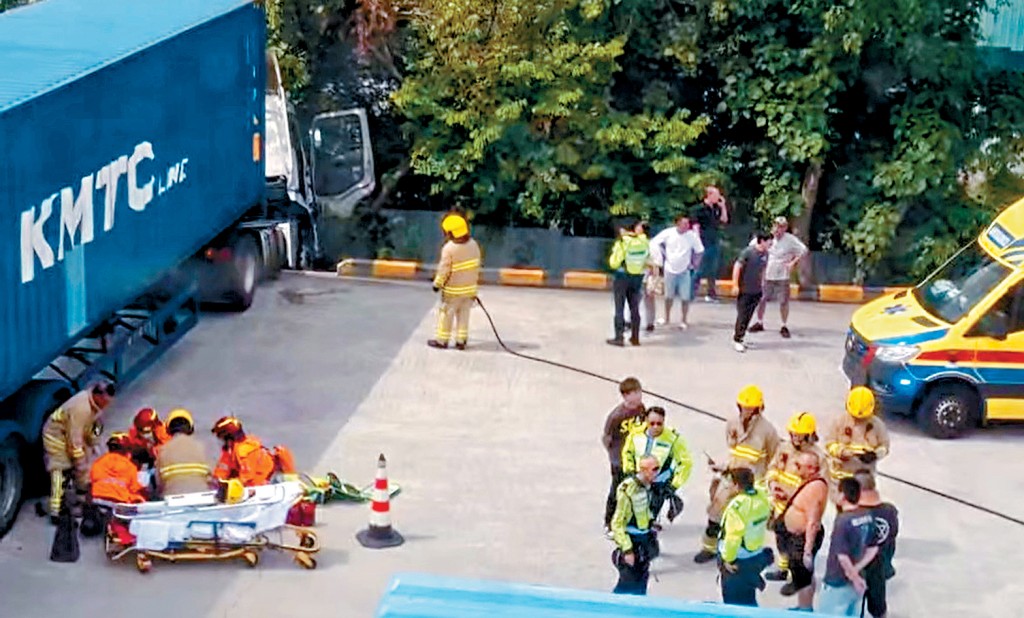 司机遭货柜车辗压后，救援人员施救，惜送院后不治。