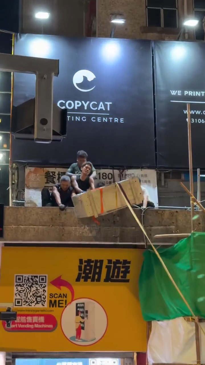 數名工人合力將分體式由地面拉上大廈平台位置。 數名工人合力將分體式由地面拉上大廈平台位置。