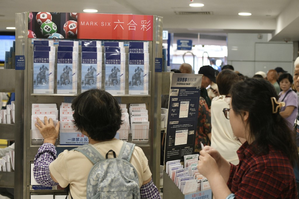 大批市民在投注站排隊購買六合彩 。資料圖片