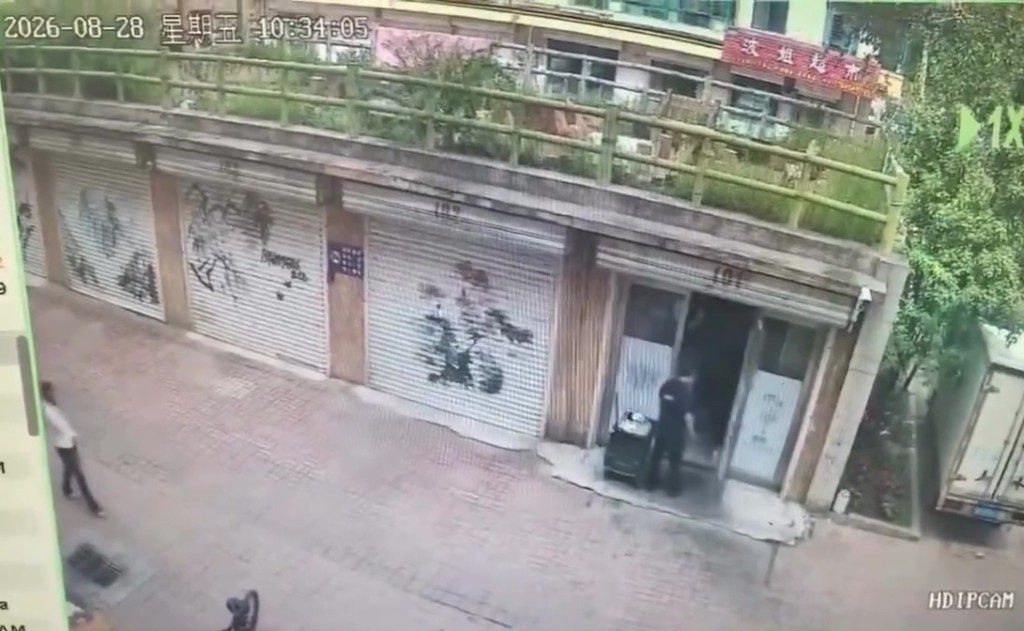 闭路电视画面显示，男子打开店舖门口。