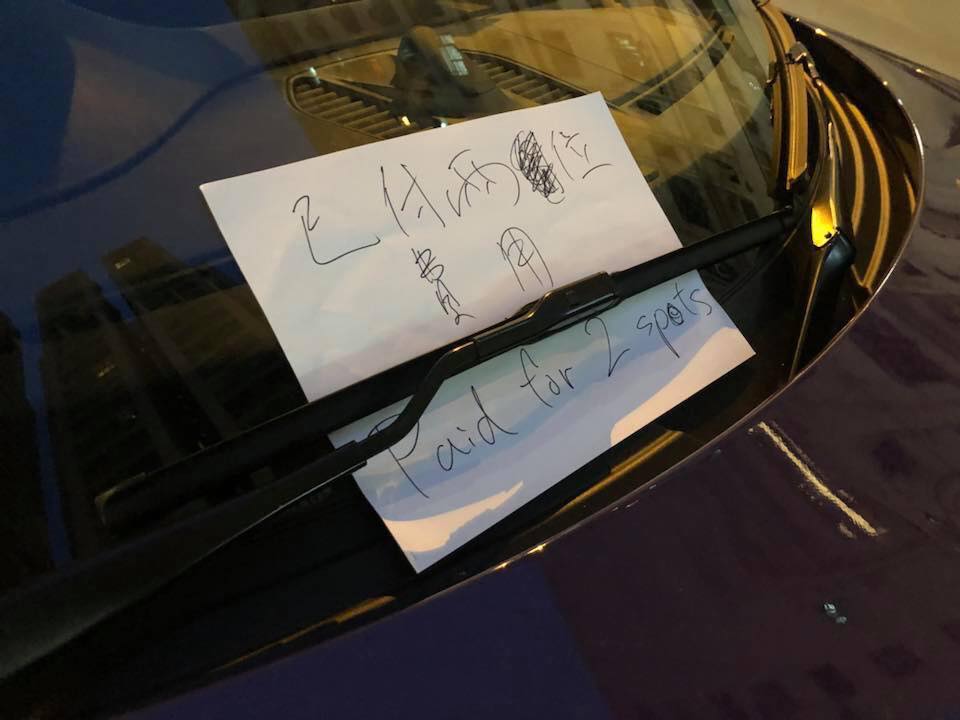 車主特意在車頭擺放一張紙,強調已付兩個車位費用。網圖