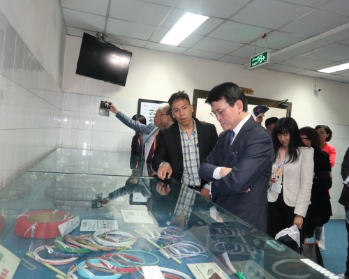 邱騰華(左五)與代表團成員到訪胡志明市出口加工及工業區管理局期間,參觀一間汽車零部件工廠。政府新聞處