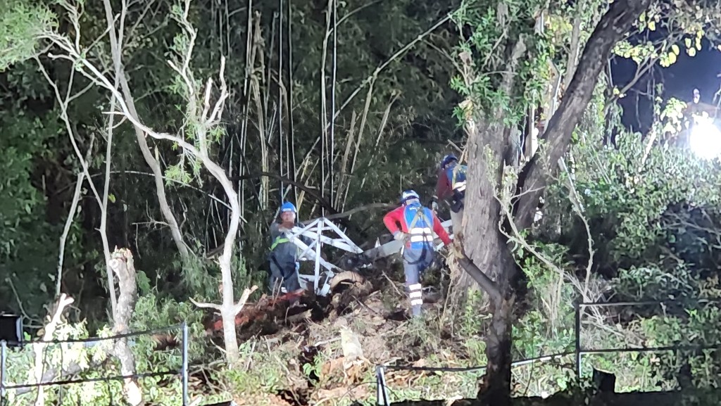 工人通宵在山坡上進行清理工作。黎志偉攝