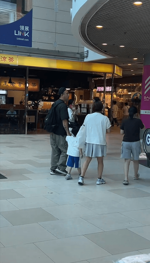 張致恒主動拖著兒子小手，盡顯其好爸爸形象。