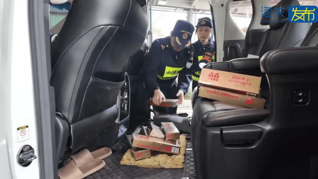 海关人员在车底暗格发现“私烟”。
