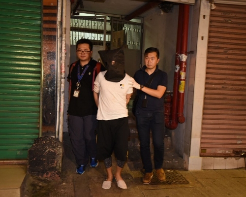 警方晚上將疑犯押到油麻地甘肅街一單位搜捕。尹敬堂攝