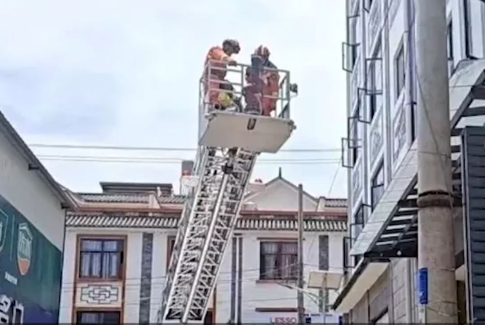 雲南有維修工在高空中暑，被困電線桿吊吊揈，要消防員架起雲梯救回。