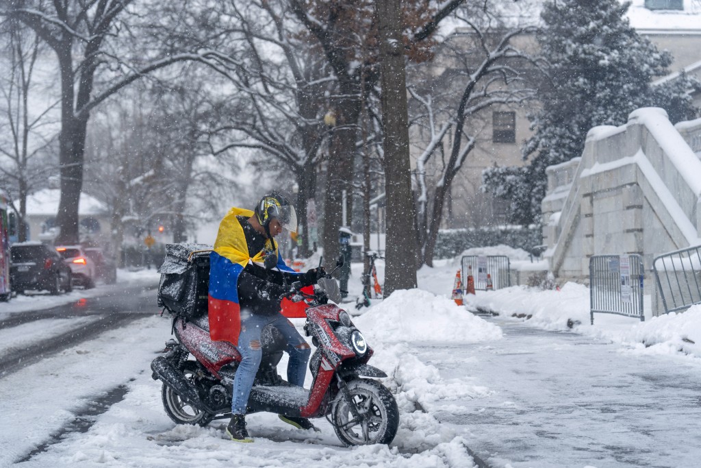 民眾雪中騎電單車。美聯社