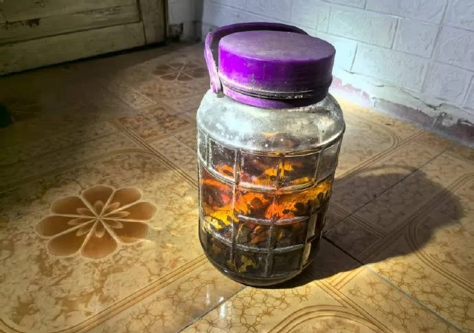 男子住處搜出酒罈。 法治日報