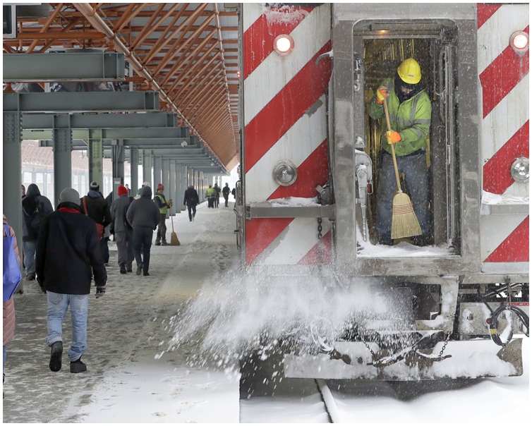 工人忙于清理积雪。 AP