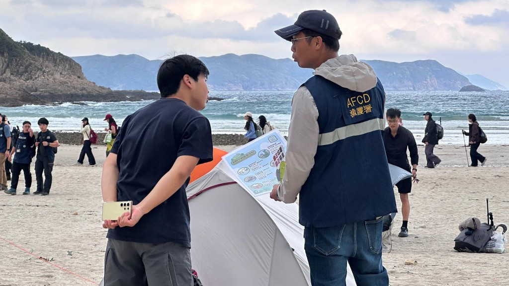 漁護署人員於西貢營地一帶向露營人士宣傳教育露營守則。
