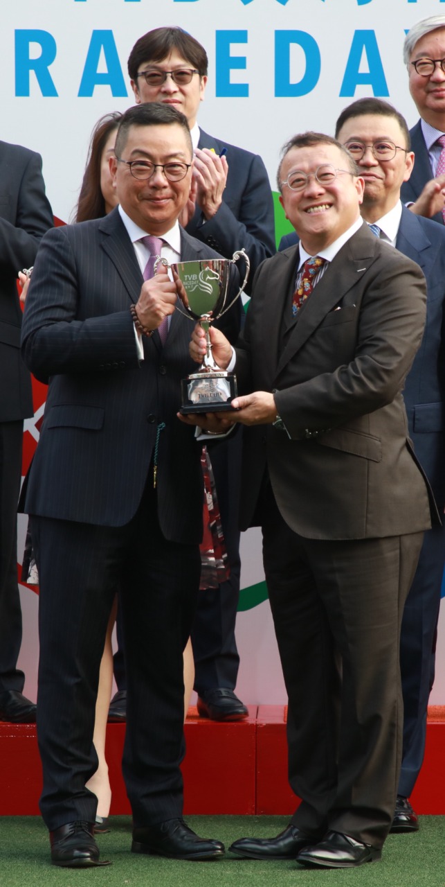 电视广播有限公司总经理（节目内容营运）曾志伟先生（右）颁发奖杯予马主代表。