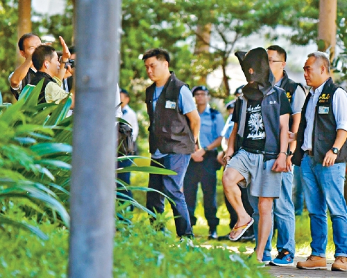 被告甘俊傑(戴黑頭套)被警方拘捕。 資料圖片