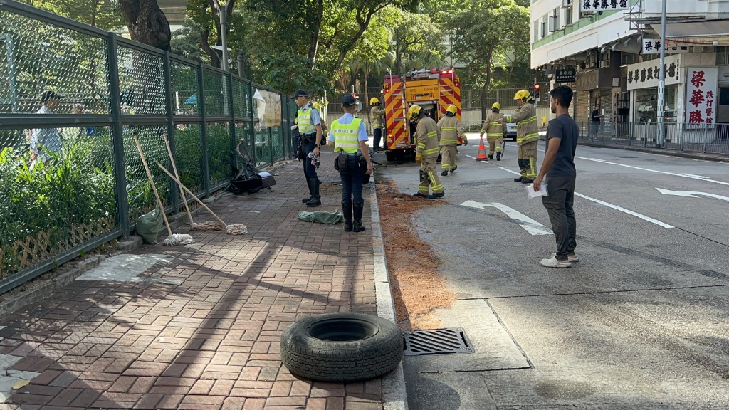 現場遺下一個車胎，消防員在油迹處鋪上木糠。林思明攝