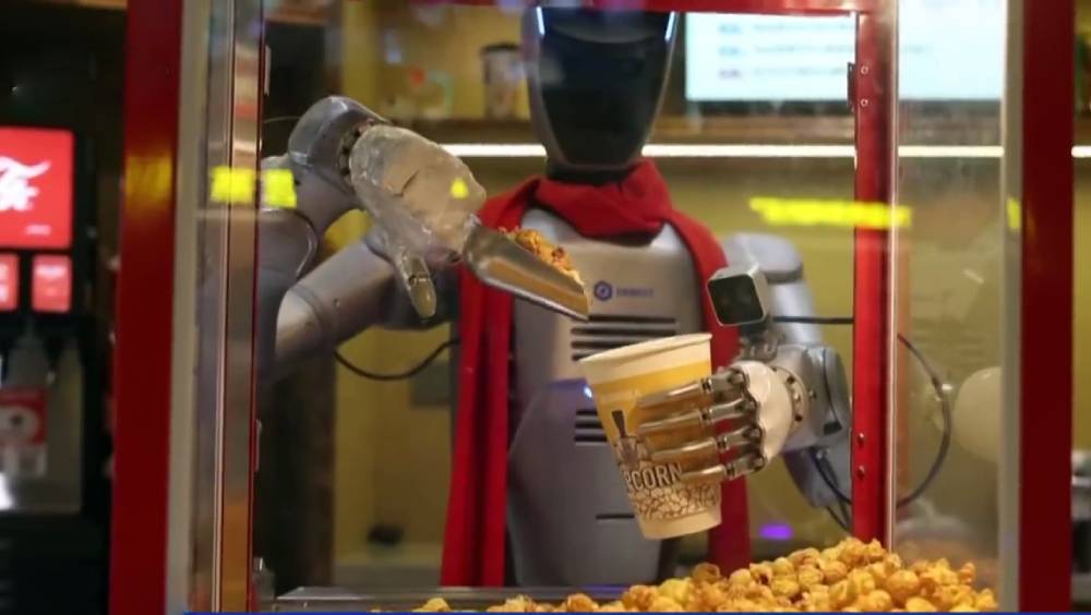 機械人進駐深圳戲院賣爆谷。 央視