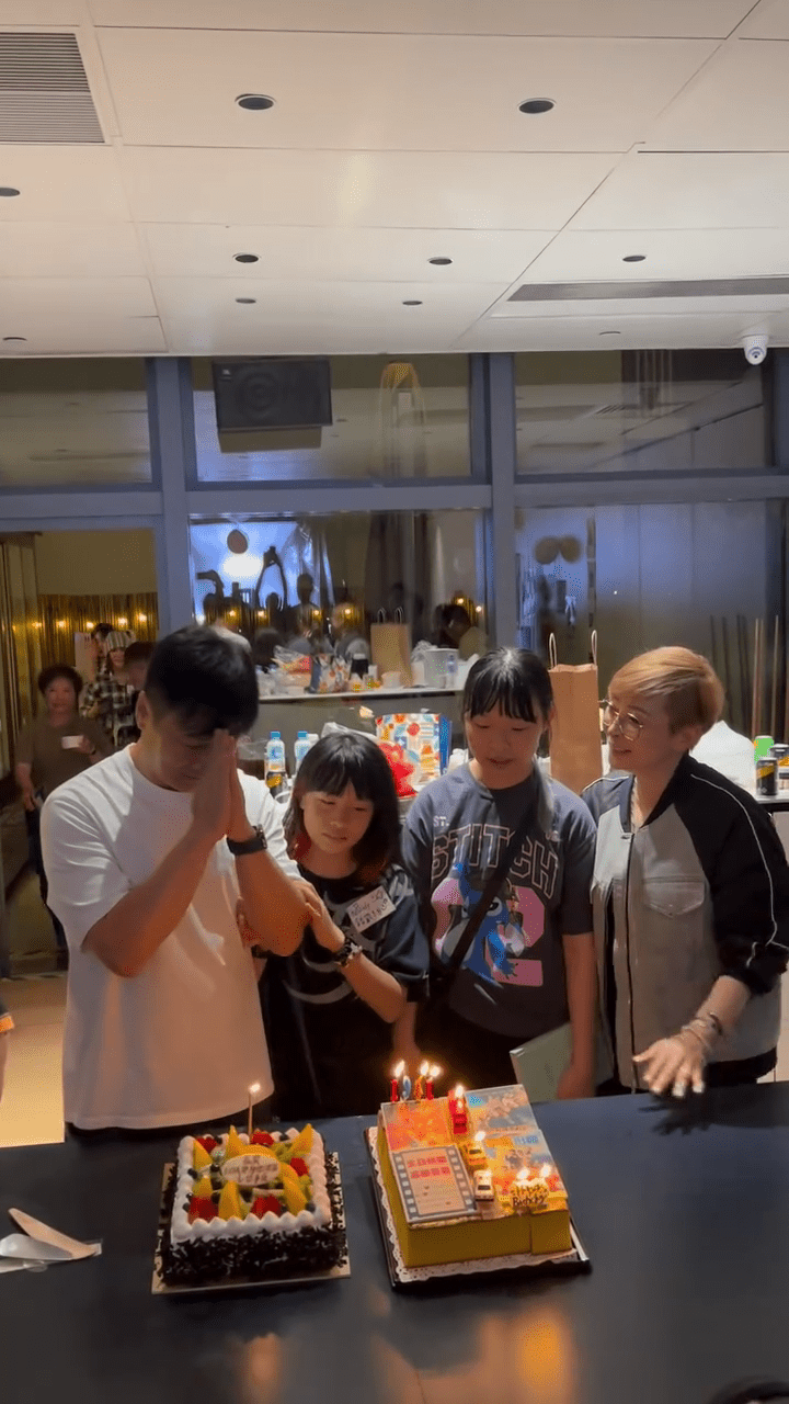 錢嘉樂與細女一同吹熄其中一個生日蛋糕上的蠟燭，大女在旁守候。