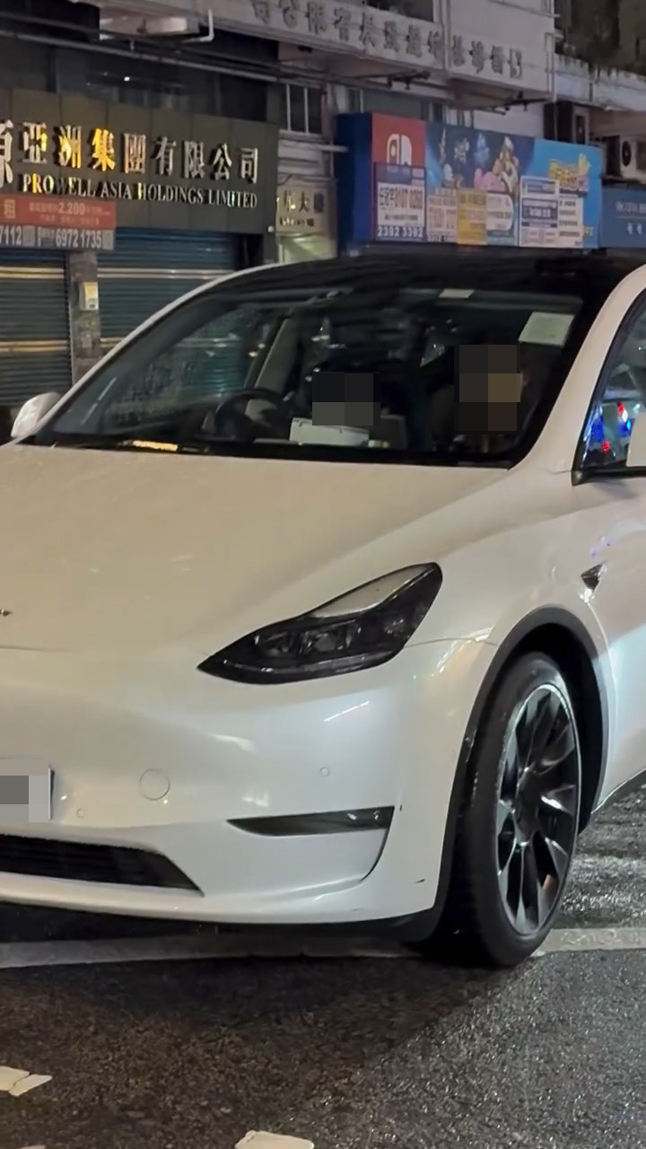一名男童坐在白色Tesla私家車的司機位上,手握軚盤操控車輛,而旁邊的女乘客未有阻止。網上片段截圖 一名男童坐在白色Tesla私家車的司機位上,手握軚盤操控車輛,而旁邊的女乘客未有阻止。網上片段截圖