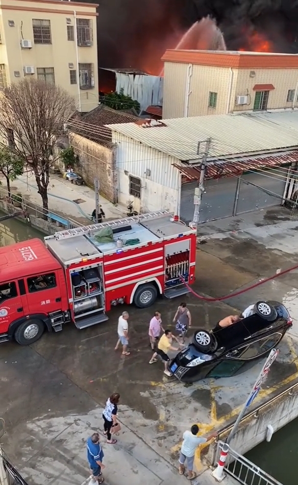 眾人合力將堵路的私家車推翻。 眾人合力將堵路的私家車推翻。
