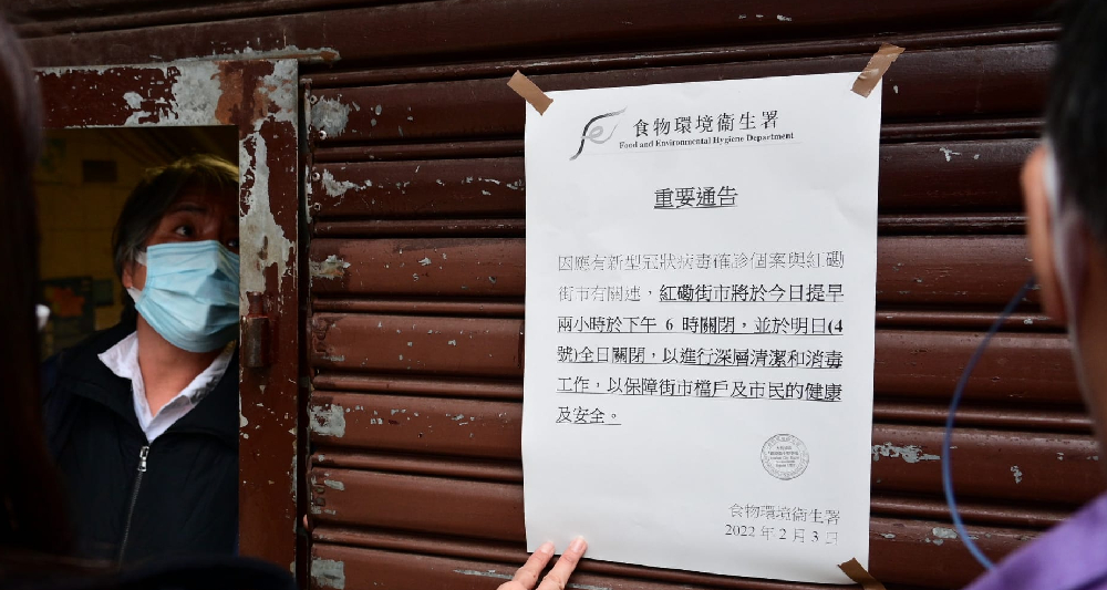 食環署的職員張貼告示，指街巿要停業消毒。