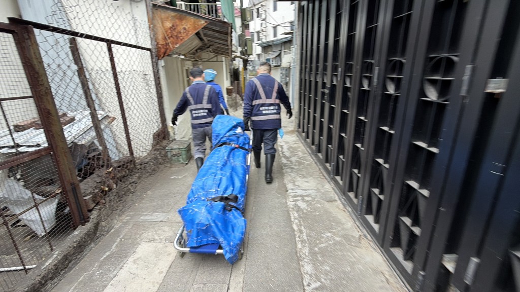 仵工將遺體移送殮房。