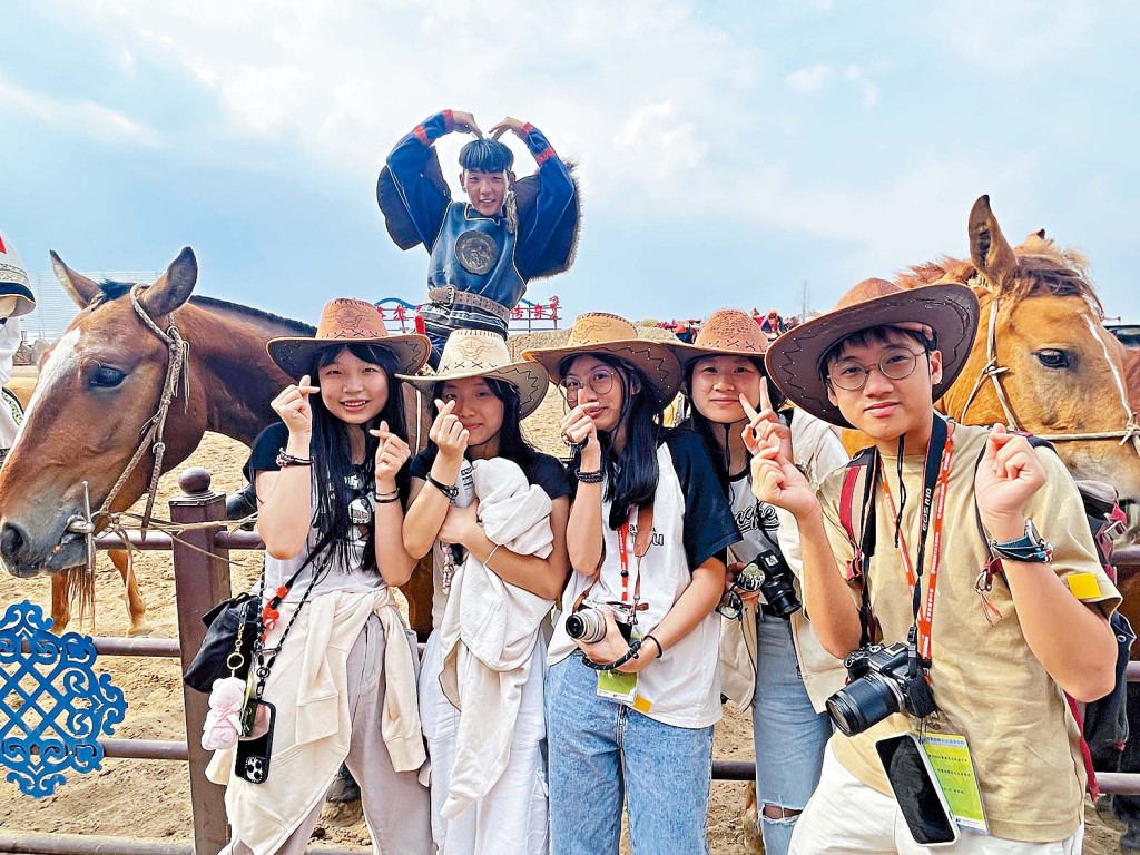 学生在内蒙草原观看牧民马术表演,惊叹表演者技术超凡,争相合照。