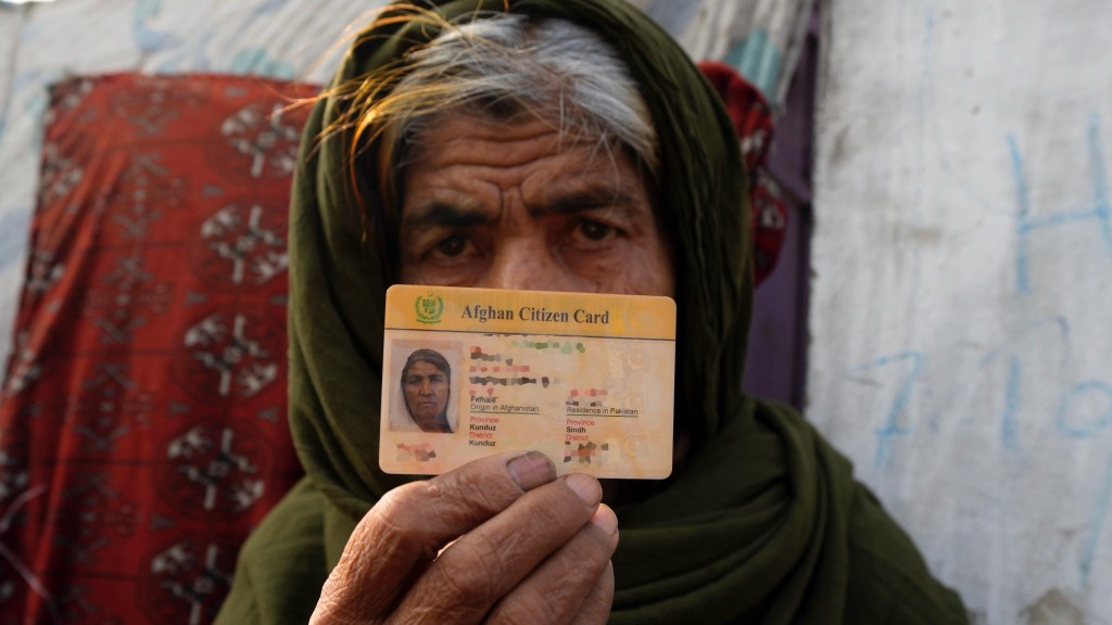 阿富汗難民向記者展示其身份證。 美聯社