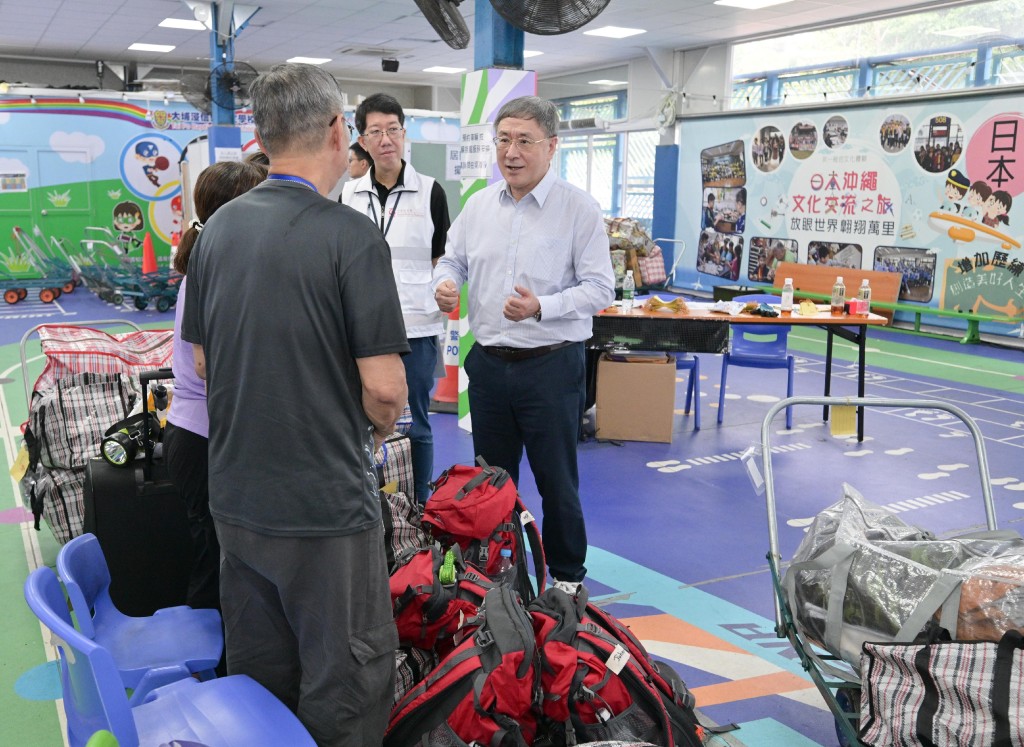 政務司副司長卓永興(右)巡視大埔浸信會公立學校內的住戶等候區,與正在等候搬運物品上車的宏泰閣居民交談。 政務司副司長卓永興(右)巡視大埔浸信會公立學校內的住戶等候區,與正在等候搬運物品上車的宏泰閣居民交談。