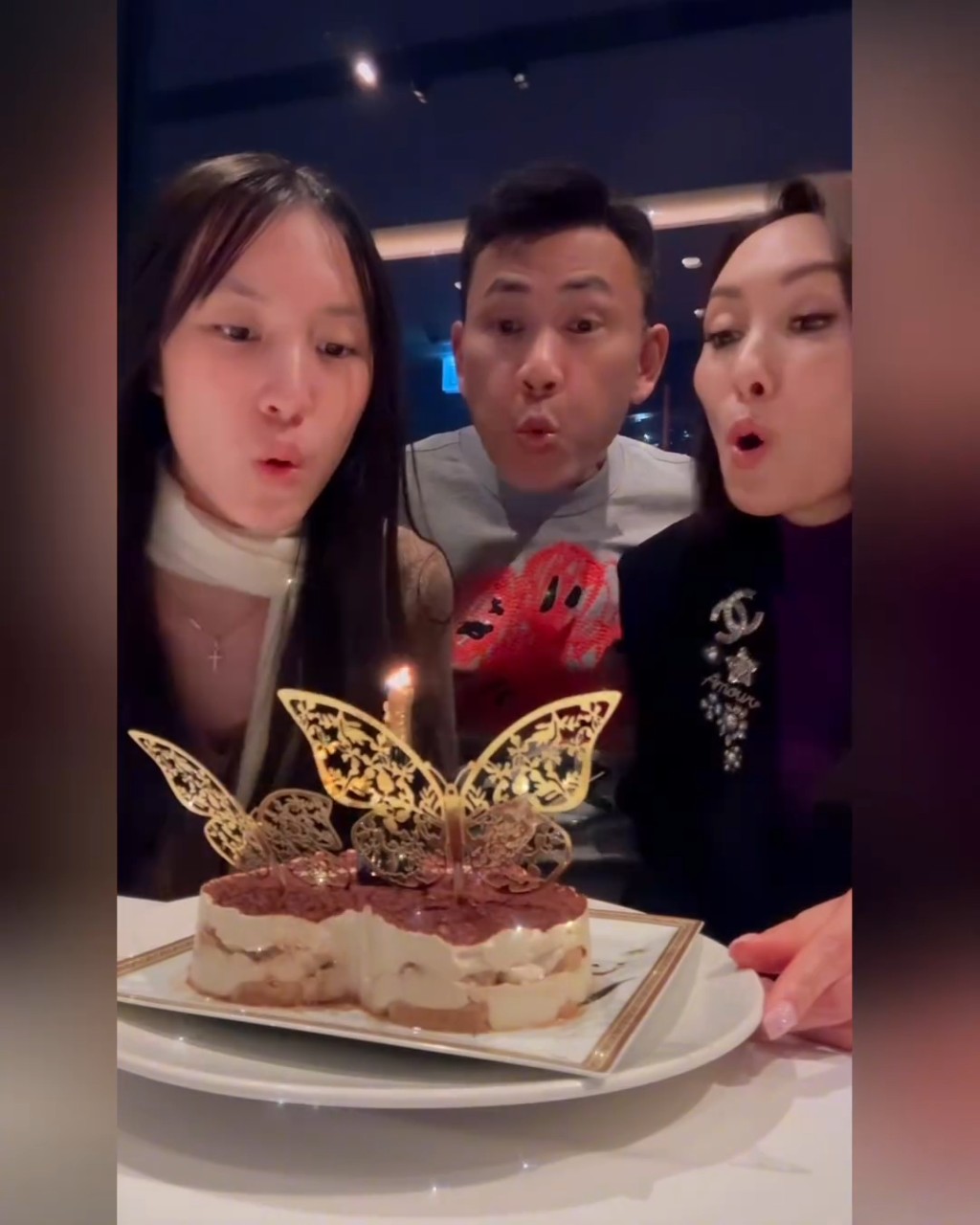 一家三口一起吹蠟燭,非常溫馨。 一家三口一起吹蠟燭,非常溫馨。