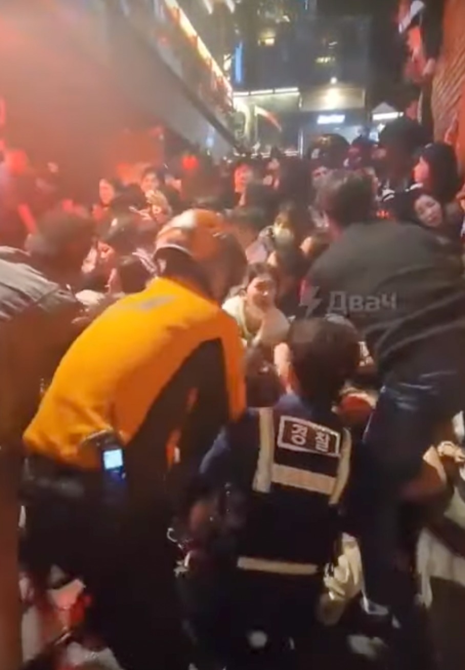 人群互相擠壓後倒地再疊高形成人牆，最終救援人員要從數疊高人堆中拉出昏迷群眾搶救。