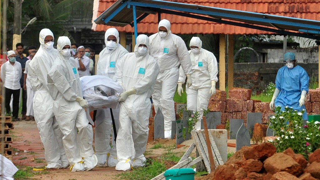 2018年科泽科德爆发尼帕疫情，医护人员和死者亲属穿着全套防护装备运送死者遗体。 路透社资料图