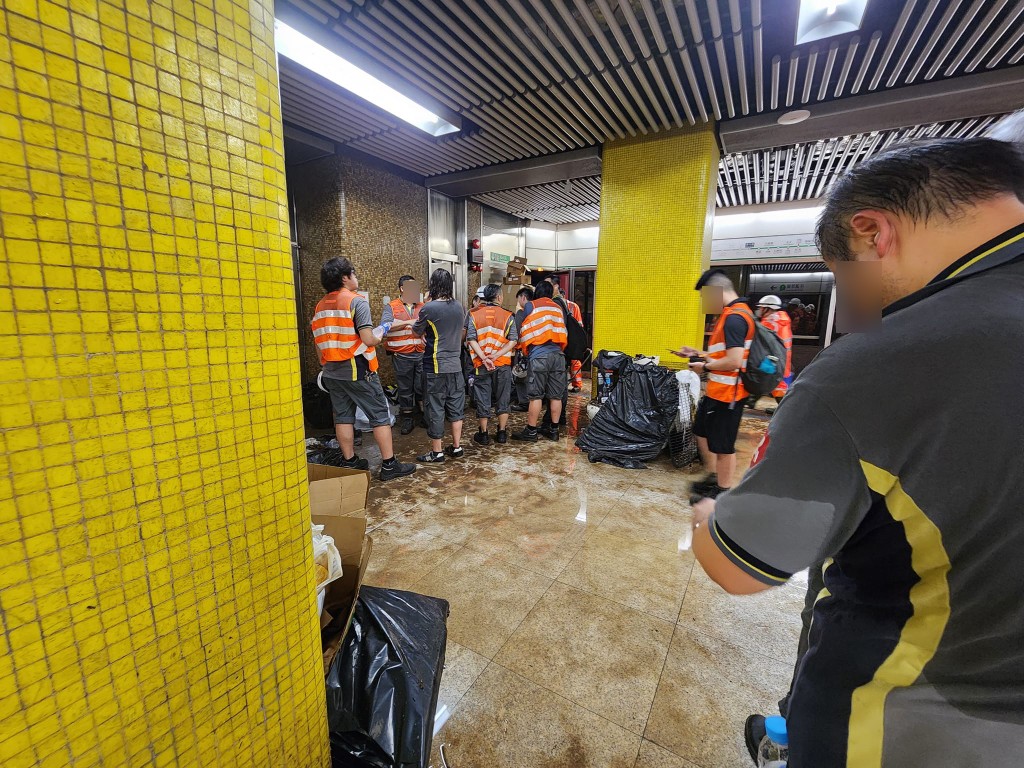  第一張相片看到有大批港鐵工程人員，正在月台集合，當中不少人頭髮及衣衫都已濕透。