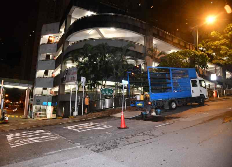 事後修路工人用瀝青將路陷鋪平。丁志雄攝