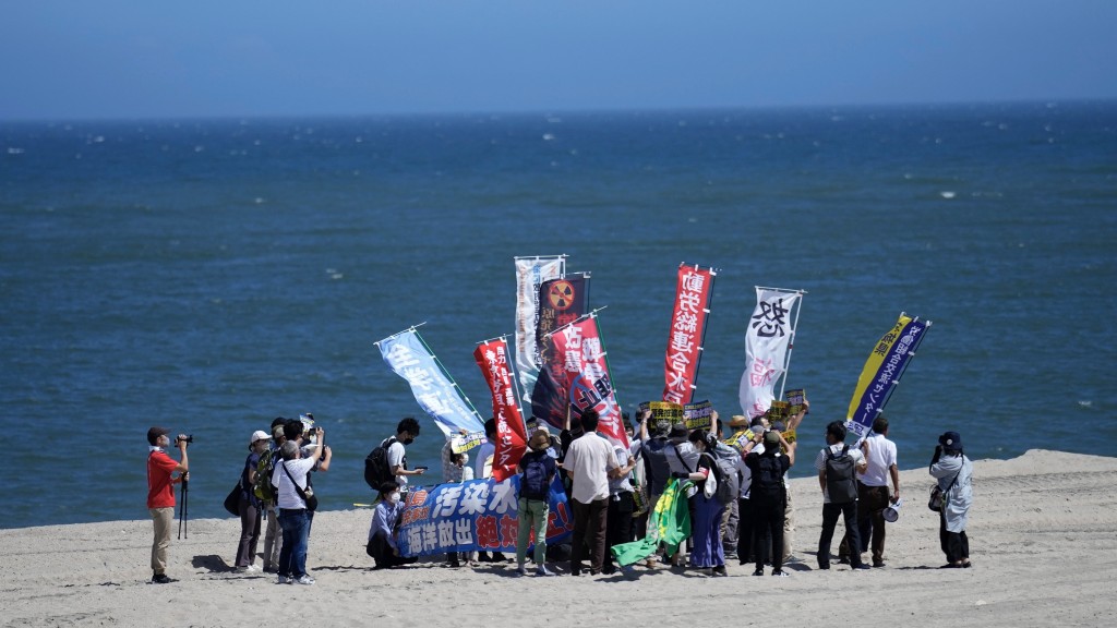 民眾在福島縣浪江町一個海灘抗議東電排放核污水。 美聯社