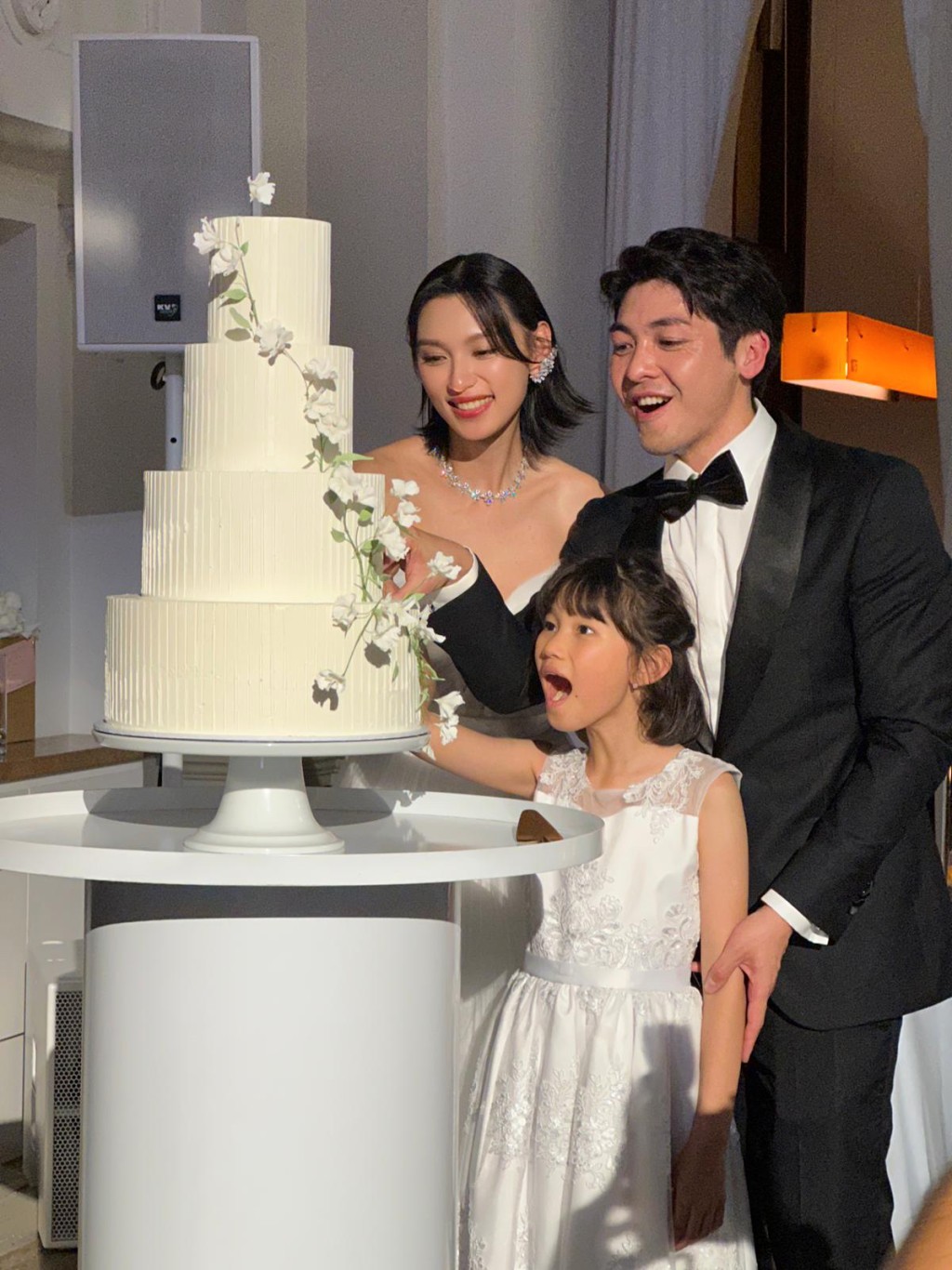 一家三口齊齊切結婚蛋糕。