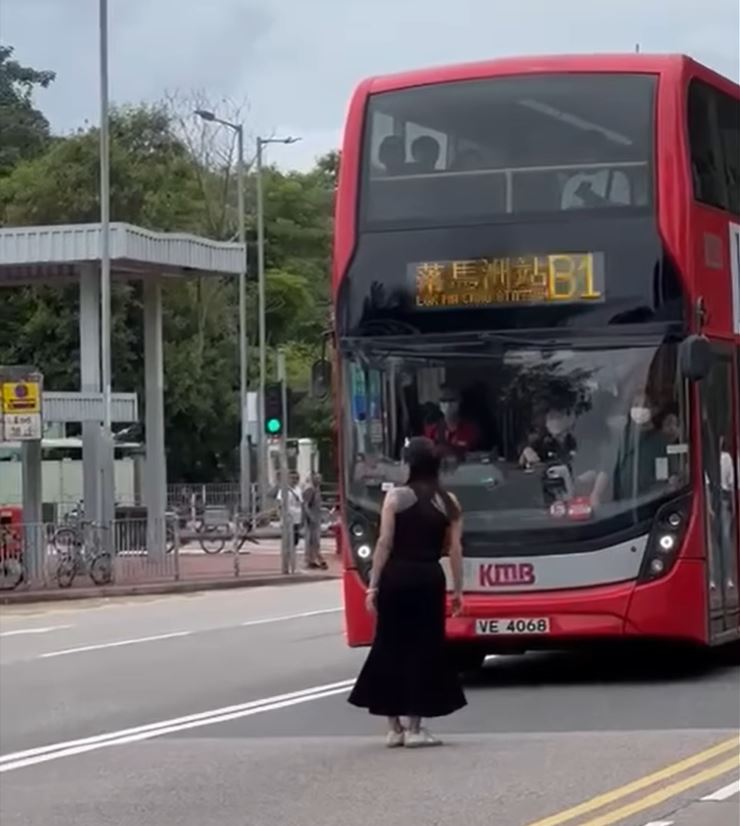 涉事女子疑不满巴士满客未停下，以肉身挡在巴士前。网上影片截图