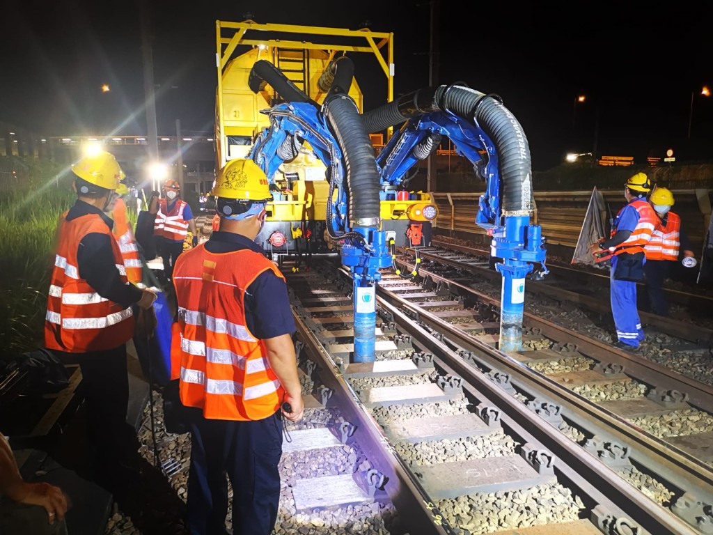 港鐵引入大型自動化道碴吸取運送機，利用智能機械臂同時吸走現有道碴及置入新道碴，再搗固及平整，提升效率。港鐵供圖