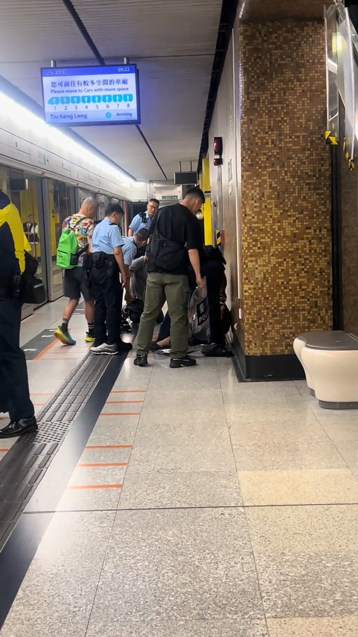 數名軍裝警及便衣警員將男子制服，按壓在地上。網上片段截圖