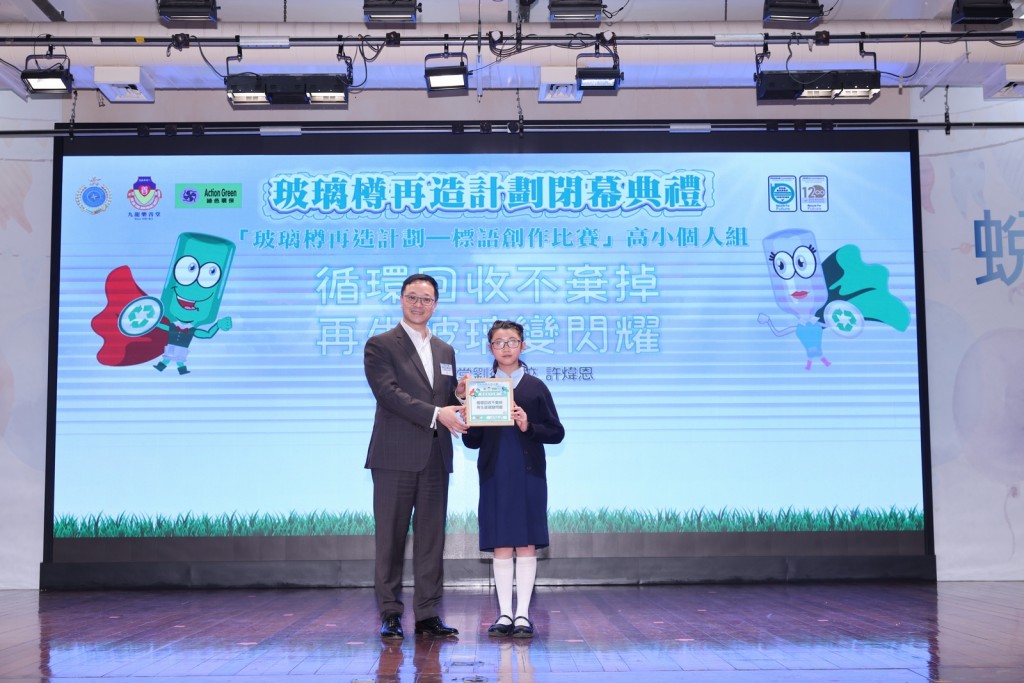 由懲教署署長黃國興先生CSDSM頒發玻璃磚獎座和書券予小學組「玻璃樽再造計劃 - 標語創作比賽（高小組）」得獎者。